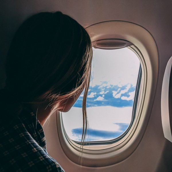 Eine Frau schaut ruhig aus dem Flugzeugfenster