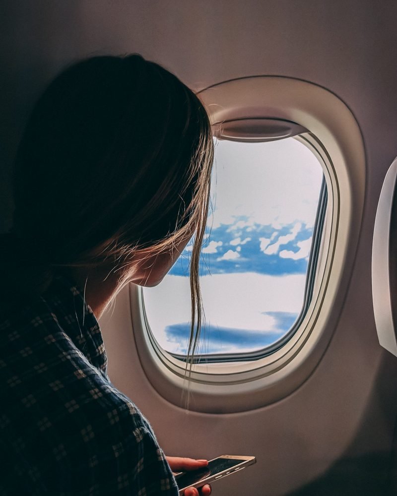 Eine Frau schaut aus dem Flugzeugfenster